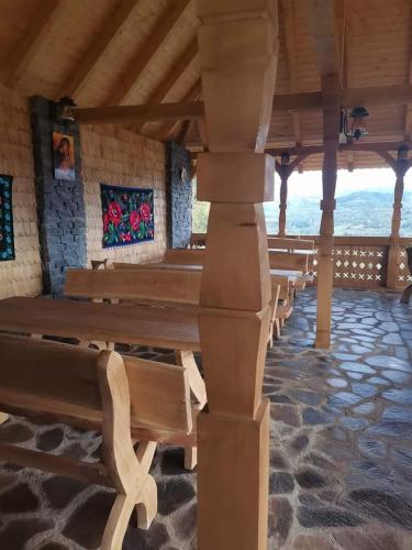 a row of wooden benches in a building at Pensiunea Valea Branzei in Năneşti