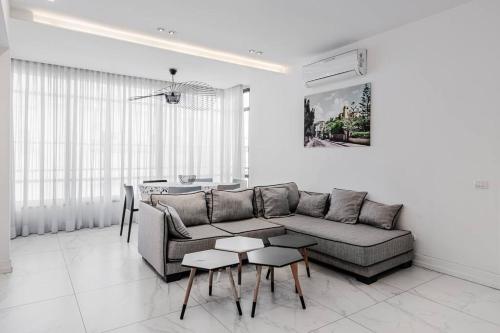 ein Wohnzimmer mit einem Sofa und einem Tisch in der Unterkunft Beautifull 3BR in Masaryk by Holiday-rentals in Tel Aviv