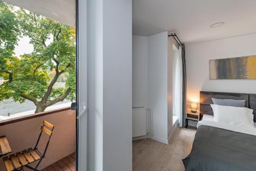 a bedroom with a bed and a window at RIVERFRONT 2BD Old Town Apartment by Hostlovers in Kaunas