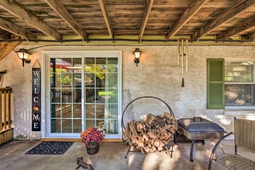 a patio with a grill and a pile of fire wood at Amish Country Apartment with Cozy Fireplace! in New Holland