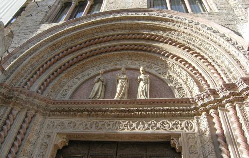 a building with two statues above a door at 2 Bedroom Beautiful Apartment In Deruta in Deruta