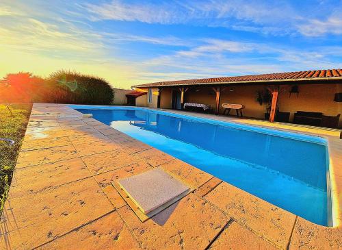 a swimming pool in front of a house at Le Domaine de Laurolie in Gaujacq