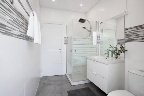 a white bathroom with a shower and a sink at Central 3BR in Ruppin by Holiday-rentals in Tel Aviv