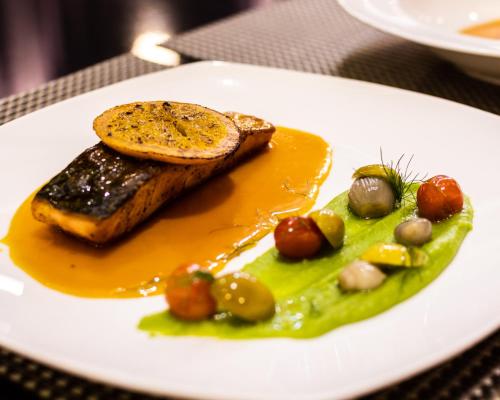 un plato de comida con un trozo de carne y fruta en Prime Asia Hotel, en Ángeles