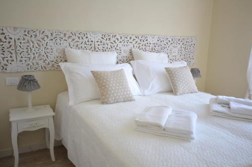 a white bed with white pillows and towels on it at Affittacamere Casa Dane' in La Spezia