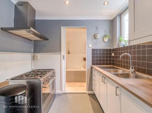 a kitchen with a sink and a stove top oven at Herenhuis in fishing village in Rupelmonde