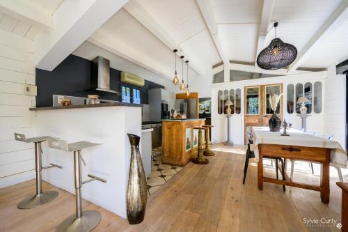 a kitchen with a table and a dining room at La dune du bien etre in La Couarde-sur-Mer