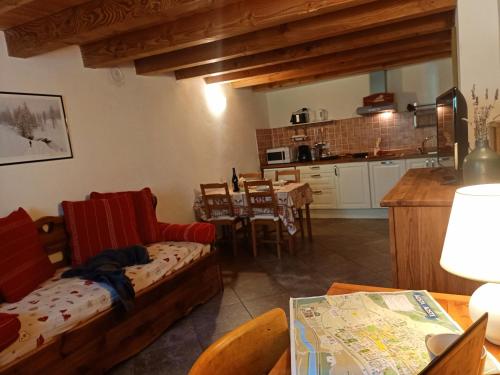 a living room with a table and a kitchen at La Fattoria di Roven in Gignod