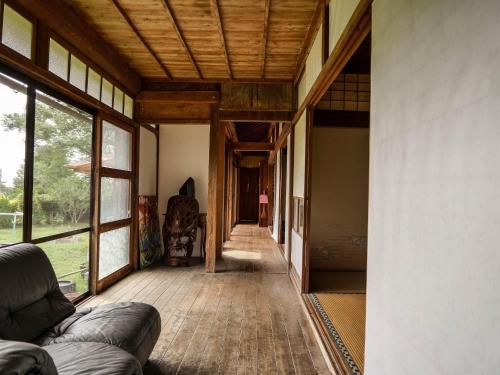 a hallway of a house with a couch and windows at 竜野園藝 in Kamimashiki