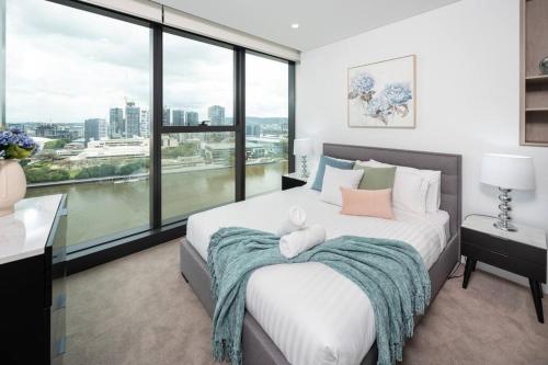 a bedroom with a large bed with a large window at 1404 Sophistication and Luxury on the Brisbane River by Stylish Stays in Brisbane