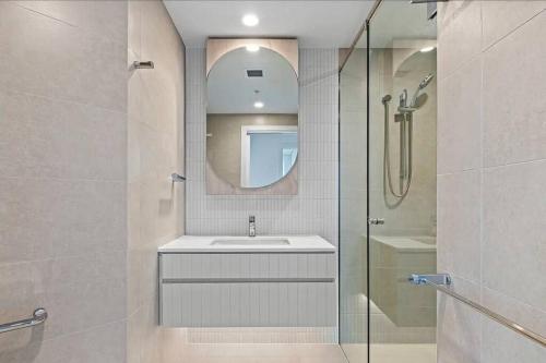 a bathroom with a sink and a shower with a mirror at 1404 Sophistication and Luxury on the Brisbane River by Stylish Stays in Brisbane