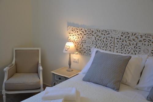 a bedroom with a bed and a chair and a lamp at Affittacamere Casa Dane' in La Spezia