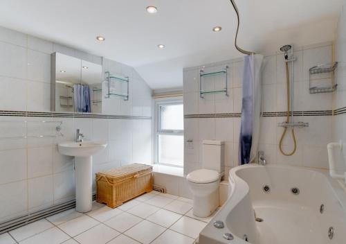 a bathroom with a tub and a toilet and a sink at Ty Manod in Blaenau-Ffestiniog