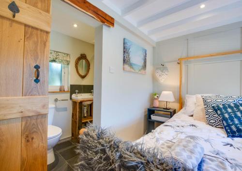 1 dormitorio con cama, lavabo y aseo en The Cabin at Bragdy, en Dinas