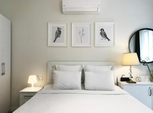 - une chambre avec un lit blanc et trois photos sur le mur dans l'établissement MY FABULOUS HOME in TAKSIM BEYOGLU, à Istanbul