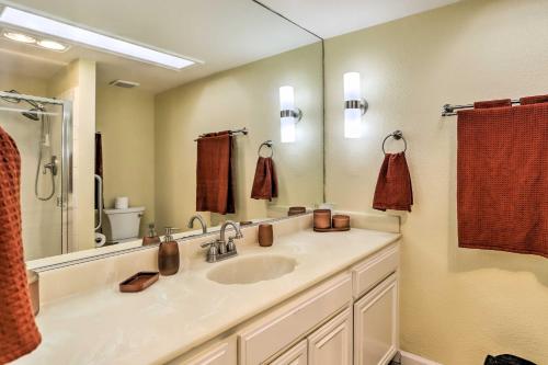 a bathroom with a sink and a large mirror at Cathedral City Golf Course Condo with Patio in Cathedral City