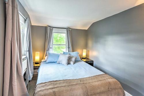 a bedroom with a bed with blue pillows and a window at Sweetwater Hideaway - Blocks to Lake Erie! in Port Clinton