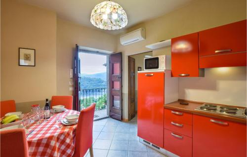 kuchnia z czerwonymi szafkami i stołem z widokiem w obiekcie Cozy Apartment In Carcegna Di Miasino No w mieście Pettenasco