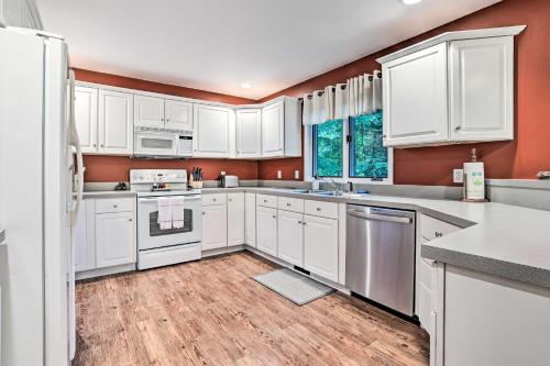 a kitchen with white cabinets and white appliances at Bellaire Ski Escape about 1 Mile to Schuss Mountain! in Bellaire