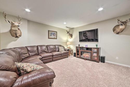 a living room with a brown leather couch and a tv at Bellaire Ski Escape about 1 Mile to Schuss Mountain! in Bellaire