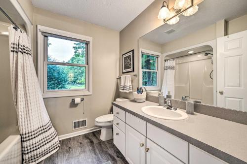 a bathroom with a sink and a toilet and a window at Bellaire Home with Golf Course View and Pool Access! in Bellaire