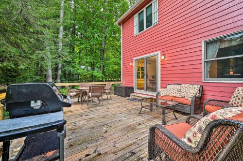 a deck with chairs and a grill on a red house at Bellaire Ski Escape about 1 Mile to Schuss Mountain! in Bellaire