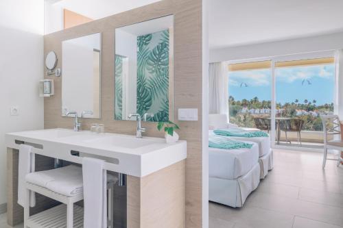 a bathroom with a white sink and a mirror at Iberostar Waves Playa Gaviotas All Inclusive in Morro del Jable
