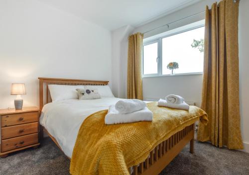ein Schlafzimmer mit einem Bett mit zwei Handtüchern darauf in der Unterkunft Tyisaf in Llanfynydd