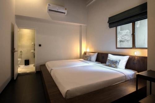 uma grande cama branca num quarto com casa de banho em Beanstalk Bangkok em Bangkok