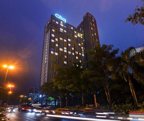 a tall building with a neon sign on top of it at Qliq Damansara Hotel in Petaling Jaya
