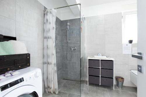 y baño con ducha y lavadora. en Apartment PATRICK with private pool en Čižići