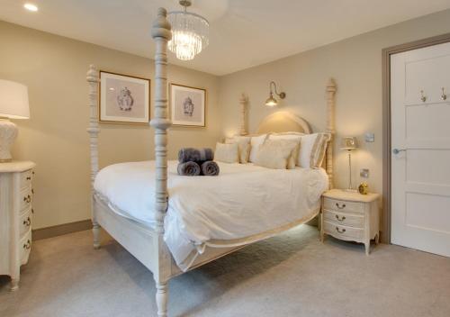 een slaapkamer met een hemelbed en een kroonluchter bij Mulberry Cottage in Conwy