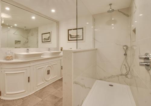 a white bathroom with a sink and a shower at Mulberry Cottage in Conwy