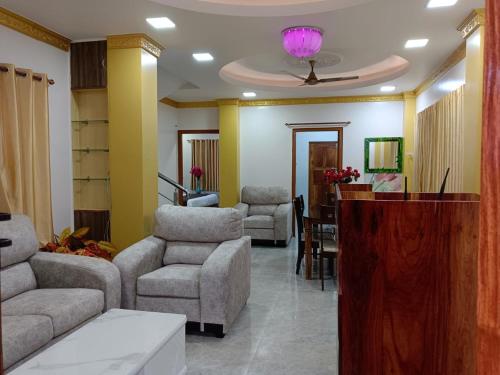 a waiting room with couches chairs and a table at Sweet Mango Tree Homestay in Port Blair