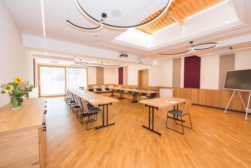 a conference room with tables and chairs and a screen at Hotel-Restaurant Gruber in Pöllau