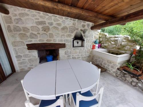 カラマーニコ・テルメにあるVilla Rico Masseria nel Parcoの石造りの暖炉の前の白いテーブルと椅子