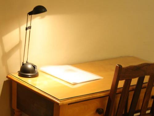 a desk with a lamp and a paper on it at River Bank Lapa in Upington
