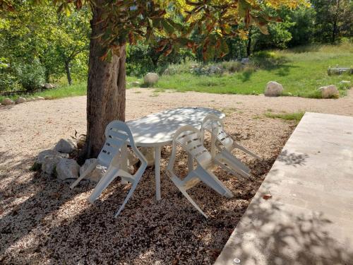 a table and chairs sitting next to a tree at Villa Rico Masseria nel Parco in Caramanico Terme