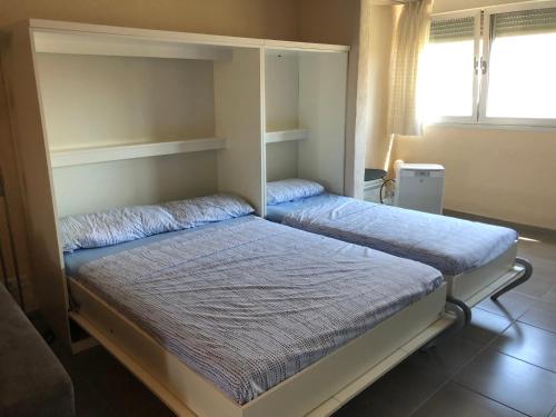 sypialnia z dwoma łóżkami piętrowymi i oknem w obiekcie Espacioso Estudio cerca de la playa La Mata w mieście La Mata