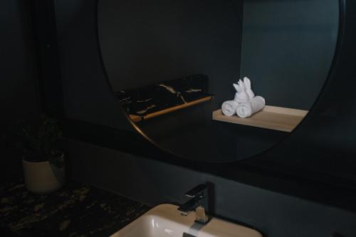 a bathroom with a mirror and a sink with towels at INN BLOG HOTEL Pakbara in Satun