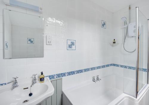 a white bathroom with a tub and a sink at Y Felin in Machynlleth