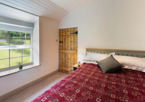 a bedroom with a bed and a window at Y Felin in Machynlleth