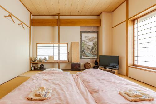 Zimmer mit einem Bett, einem TV und Fenstern in der Unterkunft Residence Ferie Nara station in Nara
