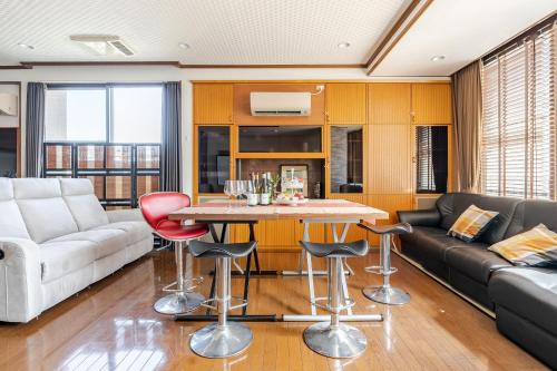 a living room with a couch and a table and chairs at Residence Ferie Nara station in Nara