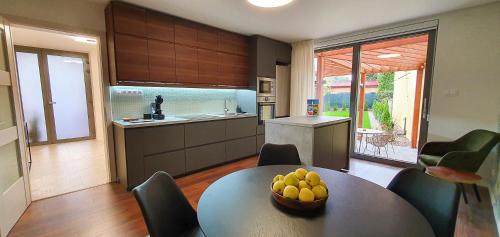 una cocina con una mesa con un bol de fruta. en Central garden residence en Levice