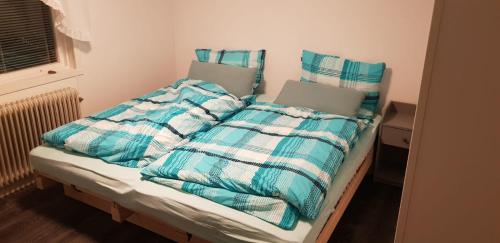 a bed with a blue and white comforter and pillows at Dream of Dalarna by Tanja in Vansbro