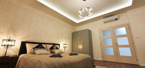a bedroom with a large bed and a chandelier at Central garden residence in Levice