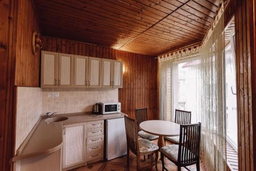 a kitchen with a sink and a table with chairs at Toga in Yablunytsya