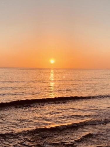 a sunset over the ocean with the sun setting at Beachfront Condo close Puerto Nuevo, Papas, and Valle de Guadalupe in Rosarito
