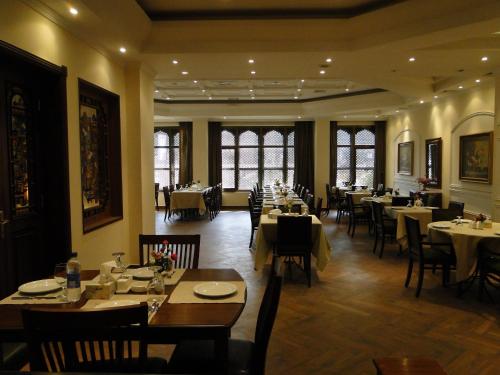 a dining room with tables and chairs in a restaurant at Shanasheel Palace Hotel in Baghdad